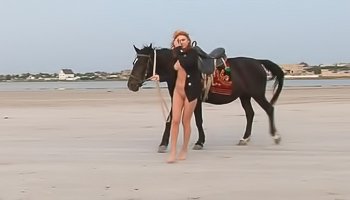 Ginger slut is riding horse outdoors