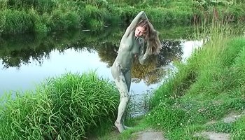 Playful teenager coats her skin with mud